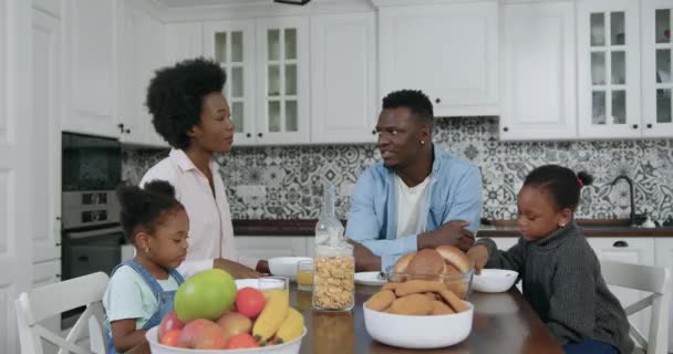 Retrato de una hermosa familia afro-americana feliz y cariñosa que se juntan en la cocina contemporánea y desayunan, de cerca, 4k — Vídeos de Stock