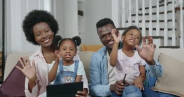 Aile kavramı, sevimli, neşeli, modern, Afrikalı Amerikan çifti ve küçük çocukları modern oturma odasında kameraya poz veriyor. Kapatın.