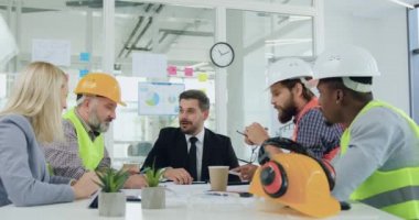 Sevimli, neşeli, mutlu, deneyimli, çelik yelek ve kasklı mühendislerden oluşan bir ekibin ön görüşü toplantı sırasında avuç içini birlik ve ortaklık işareti olarak kullanırlar.