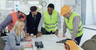 İnşaat şirketinin mühendislerinden oluşan çekici, kendine güvenen çok ırklı mühendis ekibi yönetim kurulundaki toplantı sırasında başarılı yüksek yetenekli sakallı CEO 'larıyla inşaat çizimini analiz ediyorlar.