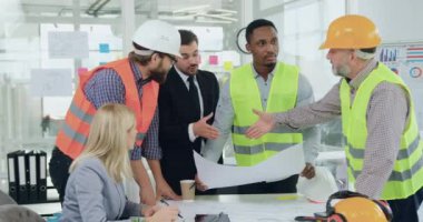 Ofisteki müteahhitlerden oluşan bir ekiple yapım projesini tartışacakları toplantıda inşaat şirketinin baş müteahhidi ile tecrübeli bir müşteri tokalaşması.