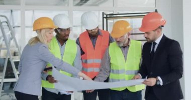 İyi görünümlü, kendine güvenen, kasketli ve profesyonel melez müşteriler. Müteahhitlerden oluşan bir ekip yeni binayı inceliyor ve her şeyi planlandığı gibi karşılaştırıyor.