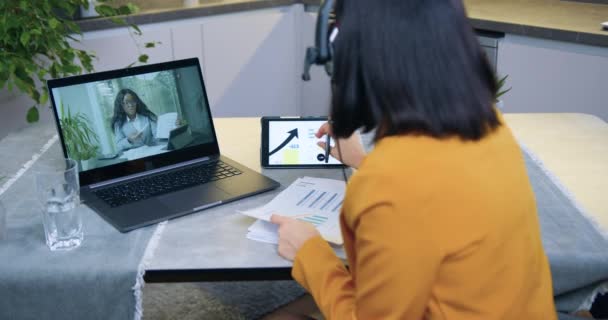 Привлекательные две международные коллеги-женщины проводят онлайн-брифинг в рамках совместного бизнес-проекта и обсуждают детали диаграмм для выбора правильной стратегии сотрудничества — стоковое видео
