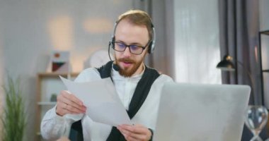 Sevimli, kendine güvenen, 30 yaşında, sakallı bir ofis müdürünün iş arkadaşlarıyla internet üzerinden konferans düzenlemesi ve mali raporları tartışması.