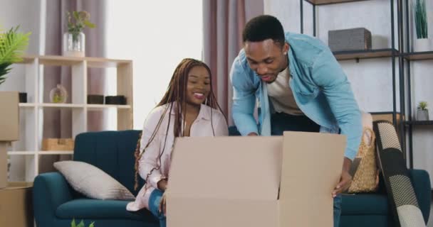 Adorable heureux joyeux jeune couple afro-américain jouer avec leurs enfants le jour du déménagement dans un appartement nouvellement acquis, concept immobilier — Video