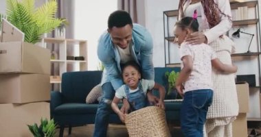 Yeni bir daireye taşındıktan sonra iki küçük kızıyla birlikte eğlenen güzel görünümlü Afro-Amerikan ebeveynlerin olduğu yeni bir aile eğlencesi.