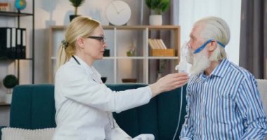 İyi eğitimli bir kadın doktor. Erkek yüzüne oksijen maskesi takıp onu evinde ziyaret ettiğinde solunum yapıyor. Sağlık sigortası kavramı.