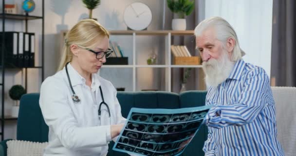 Goed uitziende vrolijke glimlach ervaren vrouwelijke arts is tevreden van mannelijke patiënten x-ray scan en het geven van hem high five tijdens huisbezoek — Stockvideo
