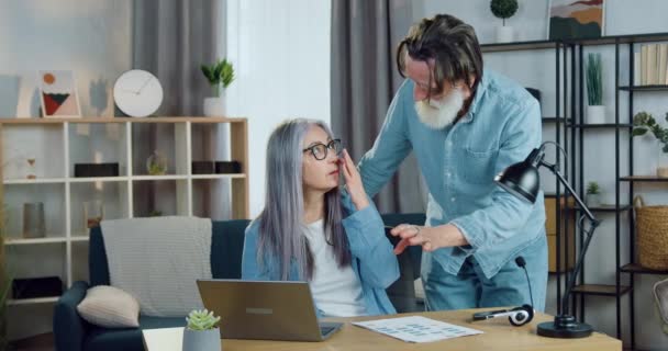 Attraktive positive glückliche erwachsene Paar spricht, wenn frische Nachrichten auf dem Laptop-Bildschirm in schön eingerichteten Wohnung, Nahaufnahme — Stockvideo
