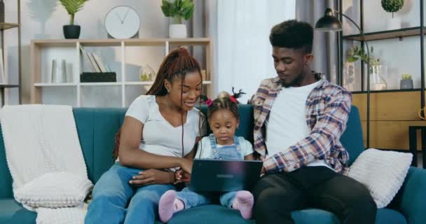 Αφρικανοί γονείς και κόρη που χρησιμοποιούν φορητό υπολογιστή για να παίζουν παιχνίδια — Αρχείο Βίντεο