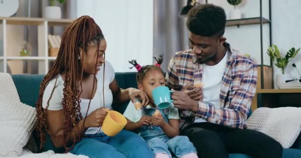 Afro-americanos pais alimentando filha com biscoitos e chá — Vídeo de Stock