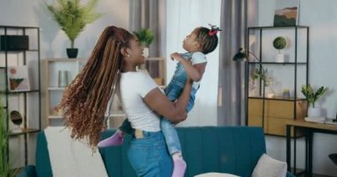 Afrikalı anne evde tatlı kızıyla oynuyor.
