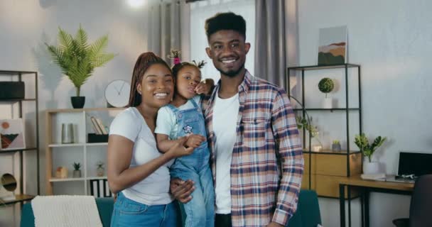 Boldog afrikai szülők, akiknek a lányuk otthon pózol. — Stock videók
