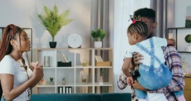 Genç baba ve anne evde kızlarıyla oynuyorlar.