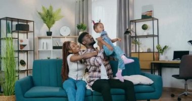 Neşeli Afrikalı ebeveynler evde kızlarıyla oynuyorlar.