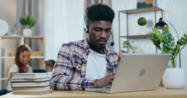 Kadın çocukla oynarken adamın bilgisayarda görüntülü konuşması.