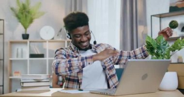 Mutlu siyah adam Compuetr ekranına bakarken el kol hareketi yapıyor
