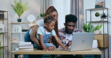 Kızı olan Afrikalı ebeveynler laptopta oyun oynuyorlar