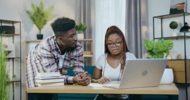 Evde modern dizüstü bilgisayar kullanan Afro-Amerikan çift.