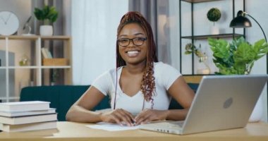 Uzaktan kumanda için dizüstü bilgisayar kullanan gülümseyen kadın.