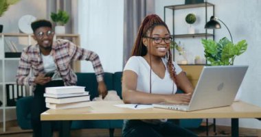 Evde akıllı telefon ve dizüstü bilgisayar kullanan Afrikalı çift