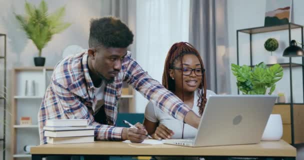 Couple assis à table avec ordinateur portable et donnant haute cinq — Video