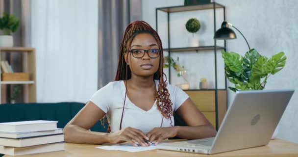 Schwarze Frau sitzt am Tisch und arbeitet am Laptop — Stockvideo