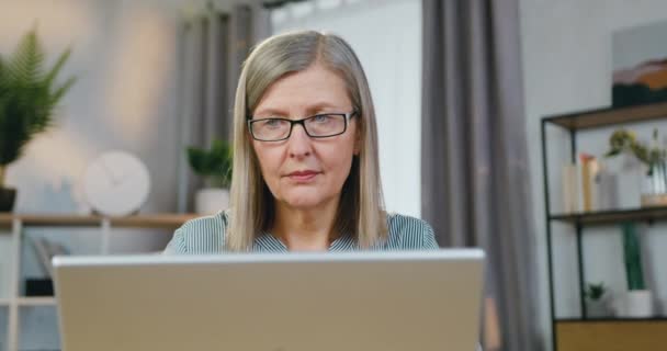 Aantrekkelijke oude vrouw met laptop tijdens de vrije tijd — Stockvideo