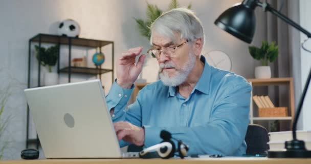 Hombre de negocios senior que utiliza el ordenador portátil para el trabajo remoto en casa — Vídeos de Stock