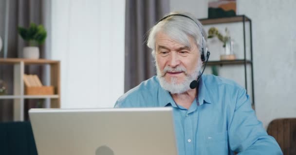 Позитивный пожилой мужчина разговаривает с родственниками по видеосвязи — стоковое видео