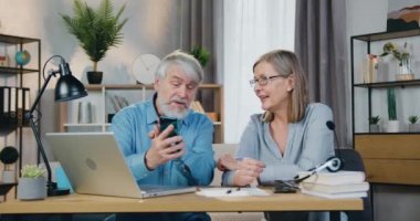 Usta adam karısına akıllı telefondan bir şey gösteriyor.