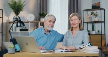 Sevimli bir çift masada oturup kucaklaşır ve aletler kullanır.