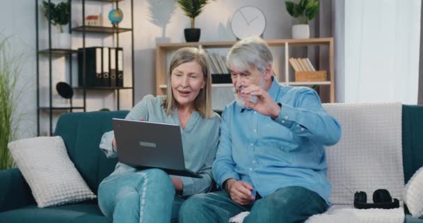 나이든 부부가 컴퓨터 화면을 보면서 하이파이브를 하는 모습 — 비디오