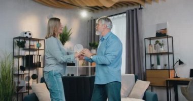 Aktif olgun aile oturma odasında ritm içinde dans ediyor.