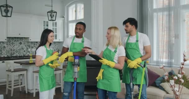 Charmante, konzentrierte blonde Frau, die den Reinigungspersonal Befehle gibt, während sie gemeinsam das Kundenhaus besuchen, um das Konzept der Dienstleistungsbranche zu reinigen — Stockvideo