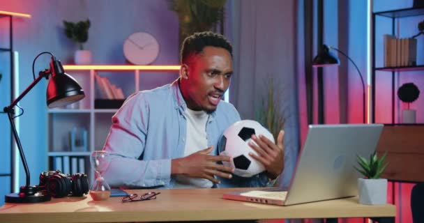 Likable animado engraçado jovem fã de futebol de pele preta assistir jogo de futebol online no computador e está insatisfeito como sua equipe favorita perdeu o jogo — Vídeo de Stock