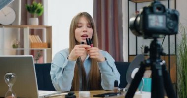 Çekici gülümseyen, kendine güvenen 25 yaşındaki bayan güzellik blogcusu internet izleyicileri için yeni video blogu kaydediyor ve makyaj detaylarından bahsediyor.