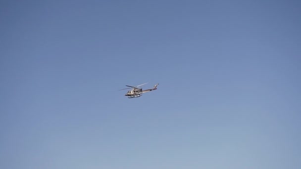 Letecká doprava. Vojenský vrtulník letící proti jasné modré obloze — Stock video