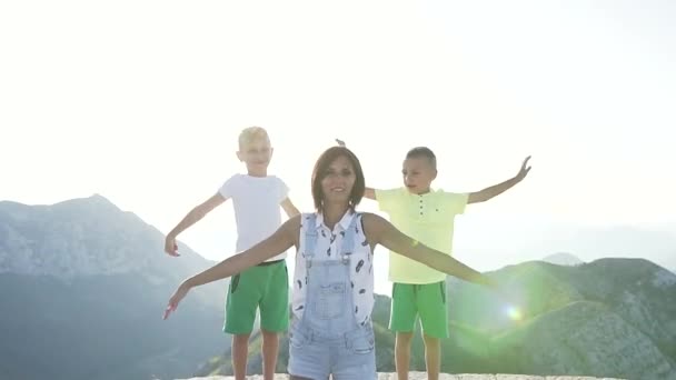 モンテネグロの国立公園の山の上で夏休みを楽しんでいる2人の美しい子供を持つ美しい若い母親日没 — ストック動画