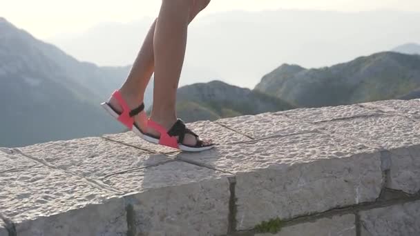 Close-up de mulheres bronzeadas pés finos em sapatos de verão, caminhadas nas montanhas. — Vídeo de Stock