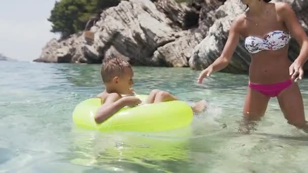 Biała młoda kobieta ze swoim synkiem, ciesząca się pływaniem w Adriatyku podczas wakacji. Na zewnątrz — Wideo stockowe