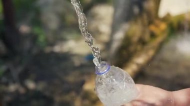 Kapat. Şişe içine akan temiz bir su akıntısı