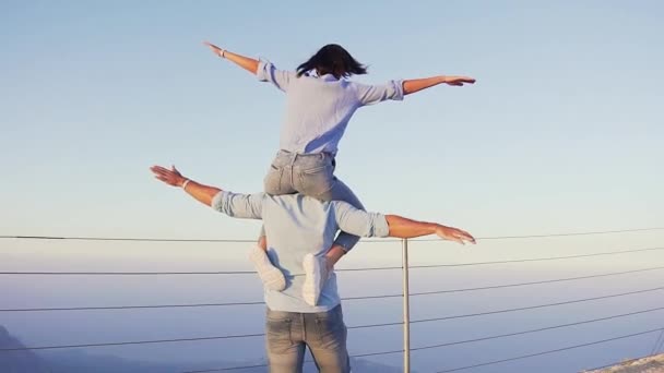Красива струнка жінка досягає мети зверху з видом на гору над морем на блакитне небо — стокове відео