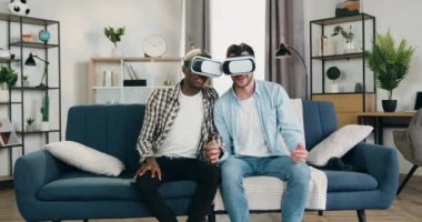 Modern teknoloji konsepti, mutlu mutlu, mutlu, genç eşcinsel çiftin evde ve ön tarafta özel 3 boyutlu gözlüklerle sanal görüntüden keyif aldıkları bir yer.