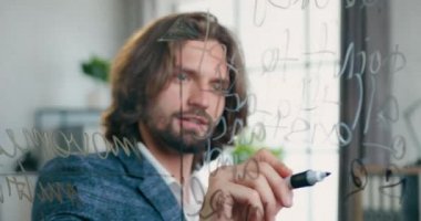 Bu cam duvara yavaş çekimde notlar yazan başarılı, kendine güvenen, başarılı, sakallı ofis yöneticisinin cam duvarından bak.