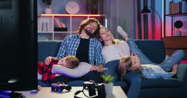 Attraktiv upphetsad blond mor väcka sin sömniga familj när de tillsammans somnade framför TV eftersom ville titta på intressant tv-show — Stockvideo