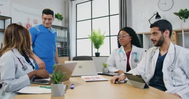 Attraktive positive qualifizierte professionelle multirassische medizinische Team begrüßen einander mit High Five vor Beginn der Arbeit in Vorstandsetagen in modernen Krankenhäusern — Stockvideo