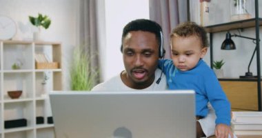 Yakışıklı, gülümseyen, mutlu, sevecen, modern, siyah tenli, evdeki küçük oğlunu önemseyen ve bilgisayar başında arkadaşlarıyla ya da akrabalarıyla konuşan bir adam.