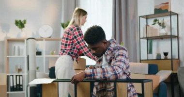 Yakışıklı, ciddi, Afro-Amerikalı bir adam. Yanında bir sürü karton kutu toplayan sakin Avrupalı kız arkadaşı...