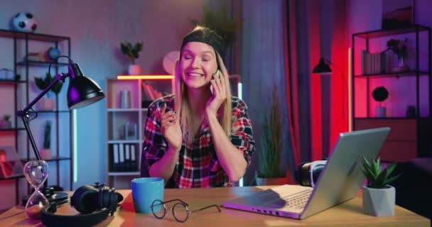 행복해 보이는 웃는 행복 한 현대젊은 여성의 사진 집에서 야간등을 켜고 스마트폰으로 감정적으로 말하는 — 비디오